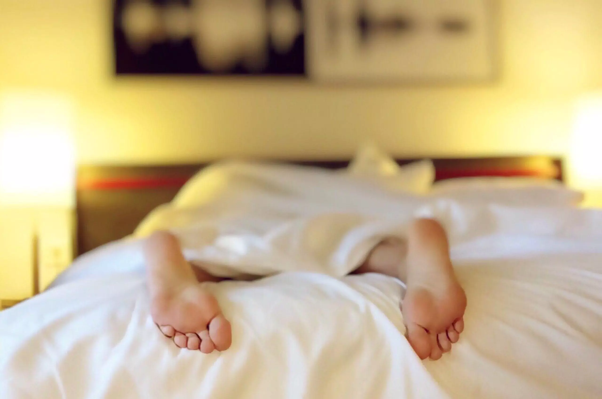 person in bed with feet sticking out