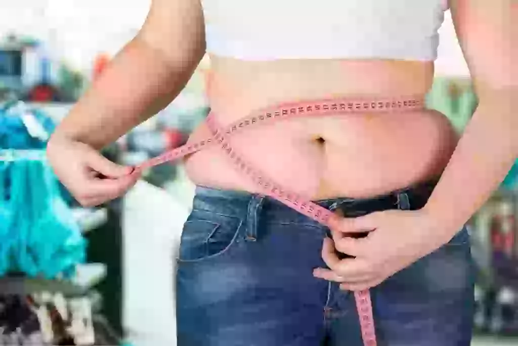 woman with measuring tape on stomach